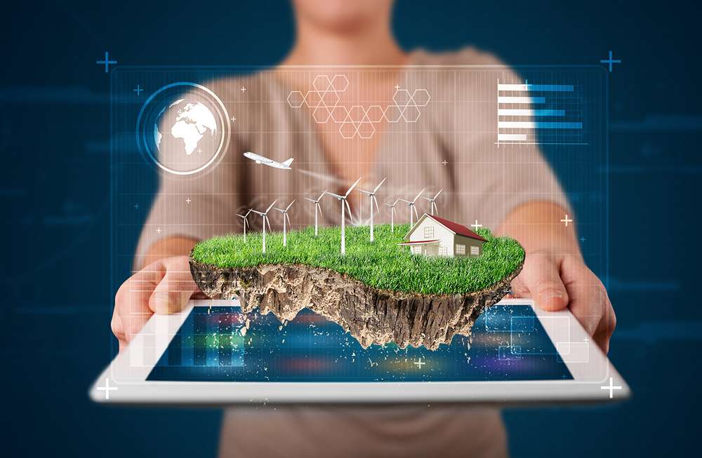 Giovane donna che presenta un perfetto terreno ecologico con una casa e mulini a vento